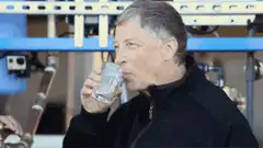 Bill Gates drinking water in a factory