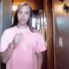 Billie Eilish dancing in pink shirt