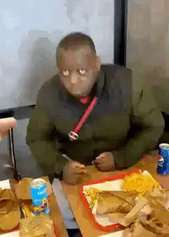 Man eating fast food looks up in shock