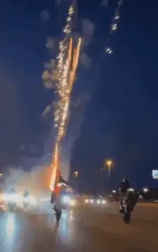 person holding fireworks on highway