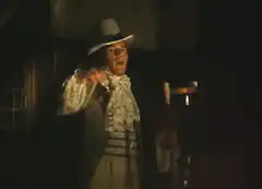 Man in 18th century costume tips hat