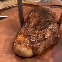 Slicing rare steak on cutting board