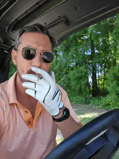 man in golf cart smoking cigar