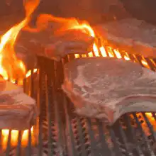 steaks grilling on a barbecue