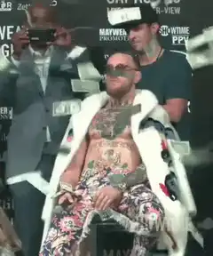 Conor McGregor sitting under money rain