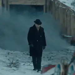 Man in coat walking through smoke