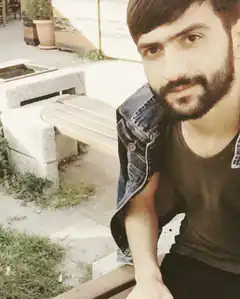 Bearded man in denim jacket sitting on bench