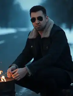 Man warming hands by fire in snow