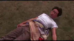 Man lying on grass with blanket