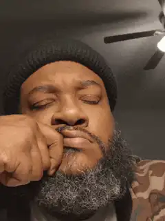 Man with beard and beanie making faces