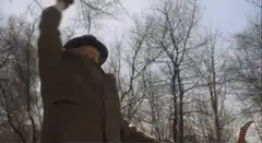 Old man with scythe in woods