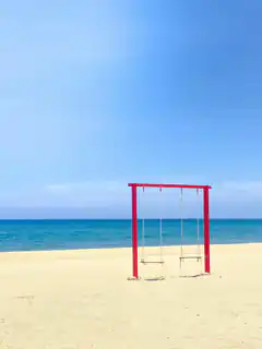 red swing set on beach
