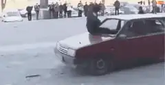 Man jumps off car hood in snow