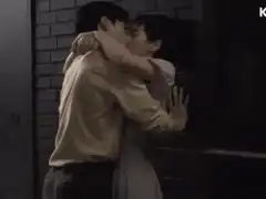 Man and woman kissing against brick wall