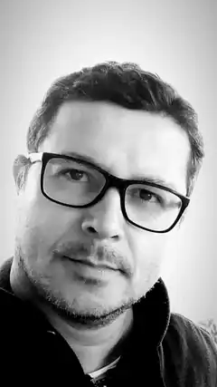 Man with glasses looking at camera