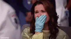 Cristina Yang crying in blue gloves