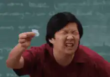 Ken Jeong squinting at a small piece of paper