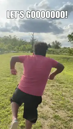 Man running excitedly across a field