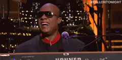 Stevie Wonder singing and laughing