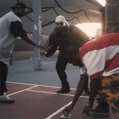 Man blows on coin on basketball court