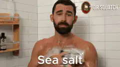 Dr. Squatch man showering with sea salt soap