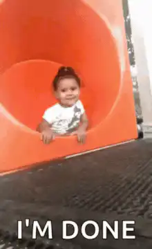 Baby slides down orange tube