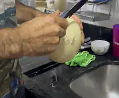 Man carving a melon with a knife