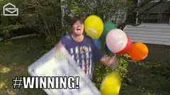 Woman celebrating with balloons and a check