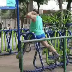 Woman exercising on outdoor elliptical machine