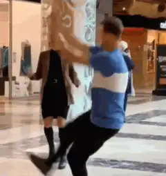 Man kicks woman in the face in a mall