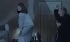 Woman bends over while men watch