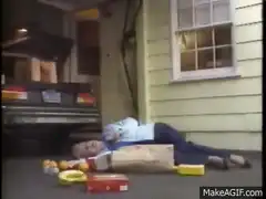 Man lying on driveway with groceries and ambulance