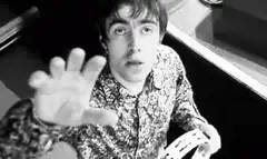 George Harrison waving and making a peace sign