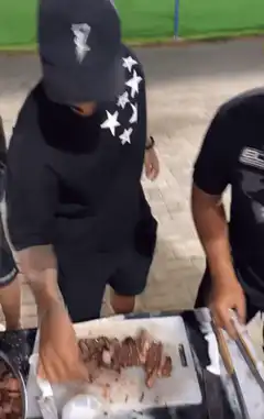 man sprinkling salt on meat