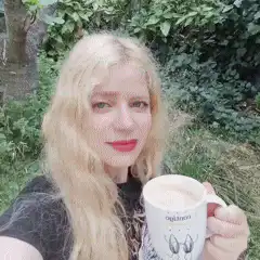 Blonde woman holding coffee mug outdoors