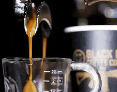 espresso pouring into measuring cup