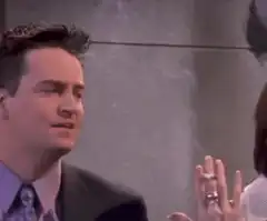 Chandler holds a cigarette in Monica's hand
