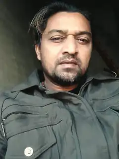 Man in grey jacket looking at camera
