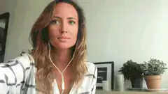 Woman with earphones looks up surprised