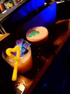 Bartender flambés a drink at a bar