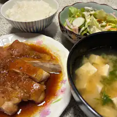 Japanese meal with grilled chicken, rice, salad, and miso soup
