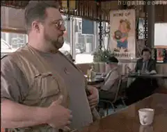 John Goodman gestures in a diner