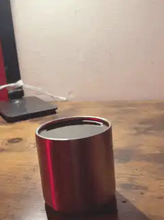 red metal cup on wooden table