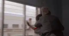 man crashes through window
