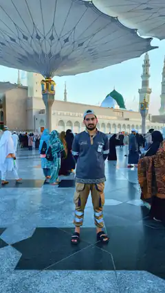 Man standing under large umbrella at mosque