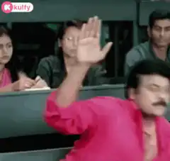 Man in pink shirt raises hand in classroom