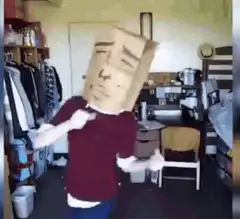 Person with paper bag head dancing