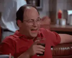 George Costanza laughing with a drink