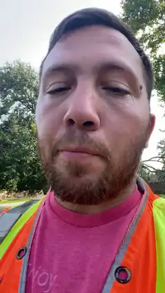 Man in safety vest with eyes closed