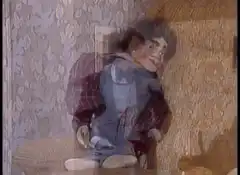 Creepy ventriloquist dummy sitting on a couch